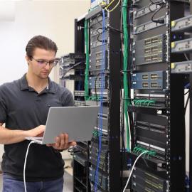 Jeune homme devant son ordinateur dans un de nos laboratoires d'informatique.